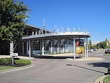 View of main entrance and drop-off area with metal sculptures along the roofline.