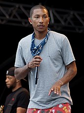 A Man wearing a blue T-shirt and red shorts, holding a microphone