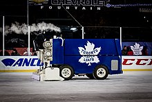 A blue-coloured zamboni with a Toronto Maple Leafs logo on its side.