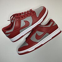 A pair of red and gray Nike Dunk shoes