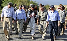 A group of about ten men walking along a road