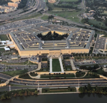 Aerial view of the huge five-sided building and its multiple rings. Parking lots and highways stretch away from it.