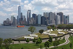 Lower Manhattan from Outlook Hill's summit, the tallest artificial hill on the island; open space, bike paths and a Staten Island Ferry boat are visible