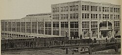 A monochromatic image of a large shopping arcade behind a viaduct