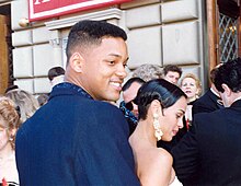 Profile of a man in a crowd of people wearing a blue-colored suit