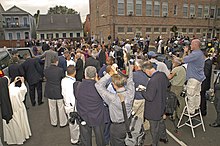 Charles and Camilla amidst a crowd of people, mostly reporters and photographers, in New Orleans