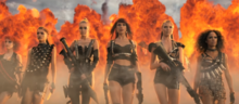 A shot of the "Bad Blood" music video showing Swift and her crew walking in front of an explosion