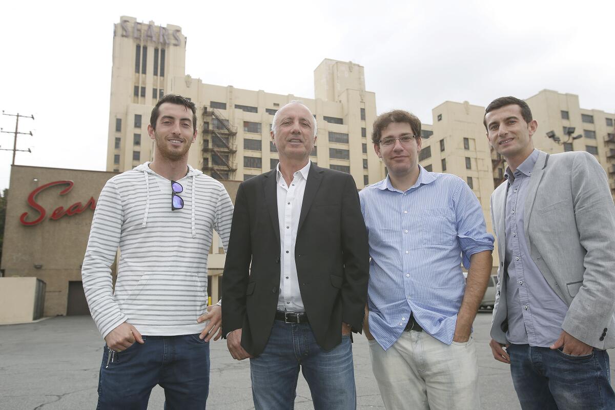 Four men stand outside the Sears building in 2013.