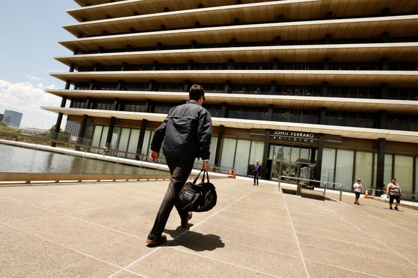 LOS ANGELES CA JULY 22, 2019 -- An FBI agent enters the downtown headquarters of the Los Angeles Department of Water and Power after serving a search warrant Monday, July 22, 2019. Authorities have declined to discuss the nature of the investigation. (Al Seib / Los Angeles Times)