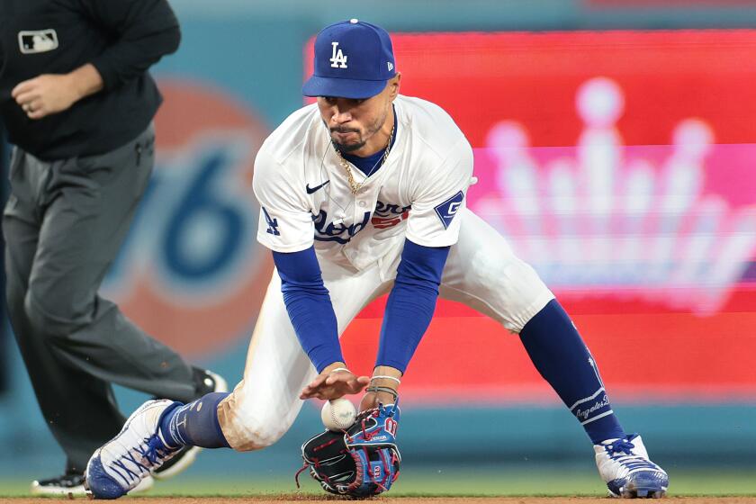 Dodgers shortstop Mookie Betts fields the ball against the Rangers during the 2024 season.