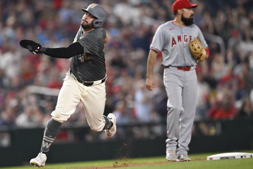 Nationals first baseman Juan Yepez rounds third past Angels third baseman Anthony Rendon on his way to scoring 