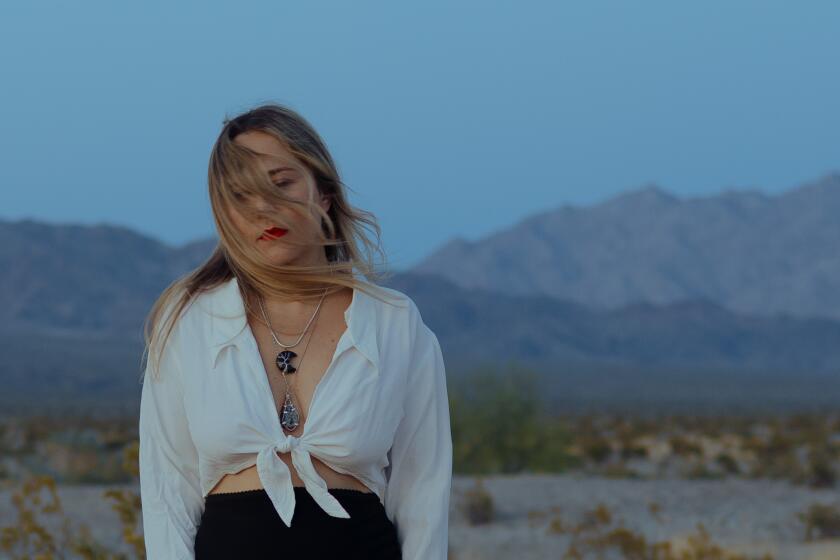 A woman stands among the Joshua Tree wilderness.