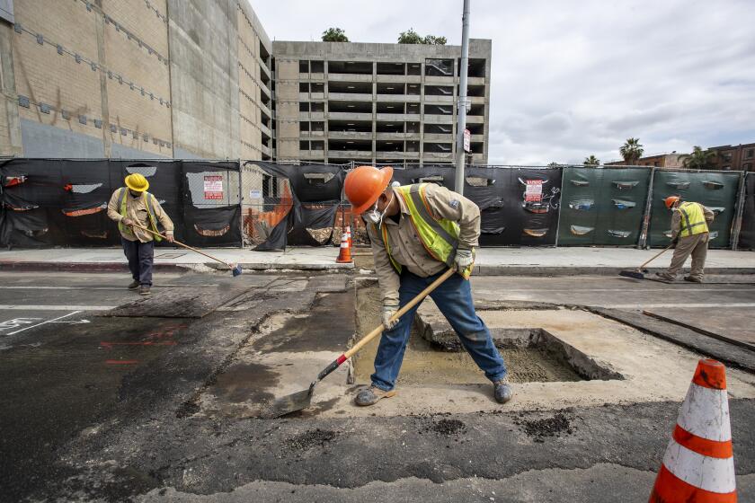 Los Angeles, CA, DWP workers install a temporary power connection for the construction site at the corner of Figueroa and W. Pico Blvd. downtown. (Robert Gauthier / Los Angeles Times)