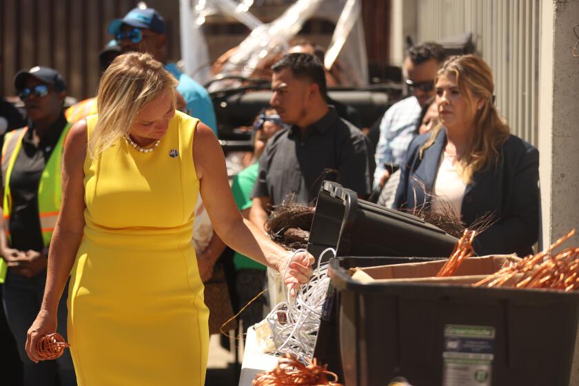 Los Angeles, CA - July 30: 11th District Los Angeles City Council Member Traci Park looks through copper as 14th District Los Angeles City Council Member Kevin de Leon speaks on a recent copper wire bust on Tuesday, July 30, 2024 in Los Angeles, CA. (Michael Blackshire / Los Angeles Times)