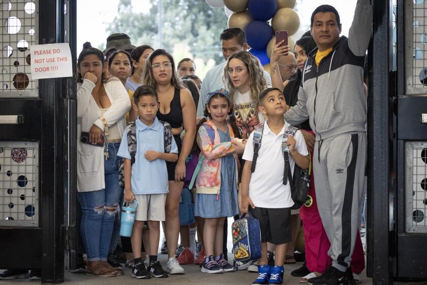 Anaheim, CA - August 10: A child weeps with her parent before joining her classmates on the first day of school for the Anaheim Elementary School District at Roosevelt Elementary in Anaheim Thursday, Aug. 10, 2023. (Allen J. Schaben / Los Angeles Times)