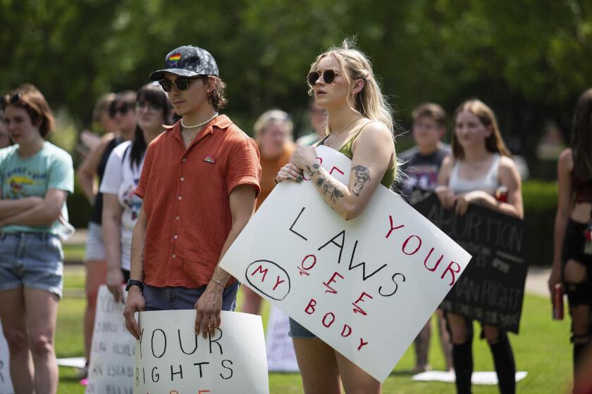 FILE - Community members gather to protest the U.S. Supreme Court's overturning of Roe v. Wade and Kentucky's trigger law to ban abortion, at Circus Square Park in Bowling Green, Ky., on Saturday, June 25, 2022. A judge cleared the way Thursday, June 30, for abortions to resume in Kentucky, temporarily blocking the state’s near-total ban on the procedure that was triggered by the Supreme Court ruling that overturned Roe v. Wade. (Grace Ramey/Daily News via AP, File)