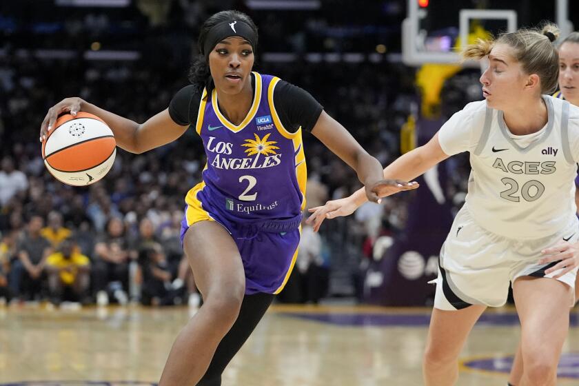 Los Angeles Sparks forward Rickea Jackson, left, drives against Las Vegas Aces guard Kate Martin.