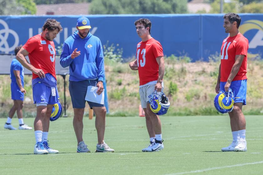 Rams quarterbacks coach Dave Ragone talks with (from left) Matthew Stafford, Stetson Bennett and Jimmy Garoppolo.