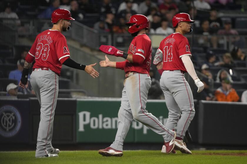 Los Angeles Angels' Charles Leblanc, left, and Michael Stefanic, center, celebrate after scoring on a double hit by Zach Neto as Logan O'Hoppe, right, prepares to bat during the fourth inning of the second baseball game of a doubleheader against the New York Yankees, Wednesday, Aug. 7, 2024, in New York. (AP Photo/Pamela Smith)