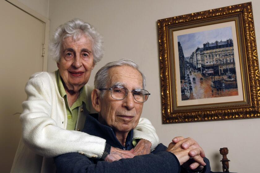 Beverly Cassirer and her husband Claude Cassier at their home in San Diego. A copy of the painting they wanted return hangs behind them.