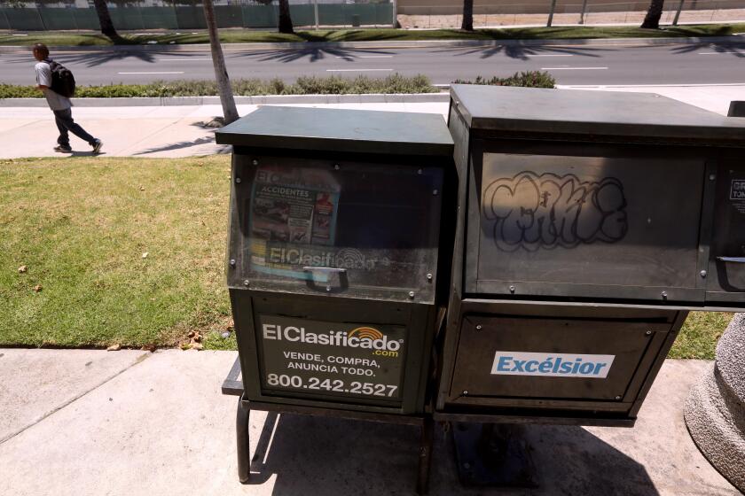 SANTA ANA, CA - JUNE 26, 2024 - An empty news rack that used to sell Spanish language newspaper Excelsior still remains standing along Bristol Street in a small shopping area in Santa Ana on June 26, 2024. There are no Spanish language newspapers being printed in Santa Ana. (Genaro Molina/Los Angeles Times)