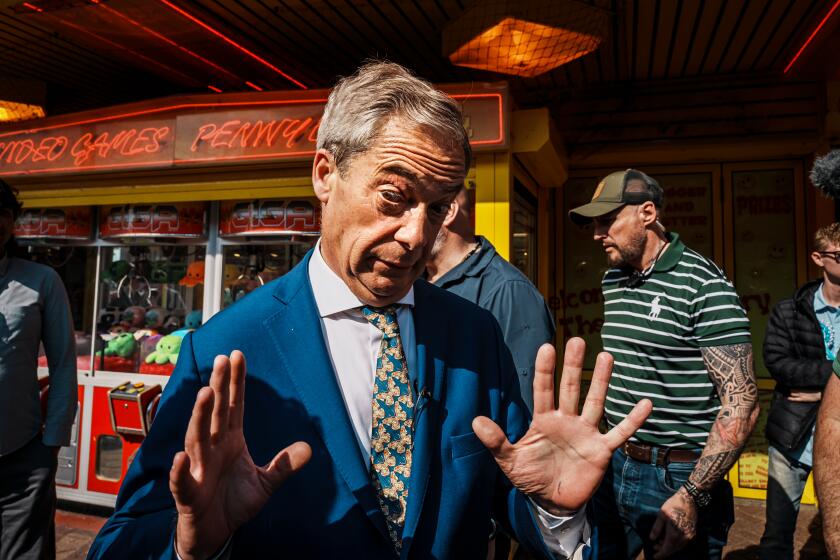 CLACTON-ON-SEA, UNITED KINGDOM -- JUNE 21, 2024: Nigel Farage, a Reform UK political party leader and running to represent Clacton in the British Parliament, react to a question from reporters outside the political party office above an arcade center, in Clacton-on-sea, United Kingdom, Friday, June 21, 2024. (MARCUS YAM / LOS ANGELES TIMES)