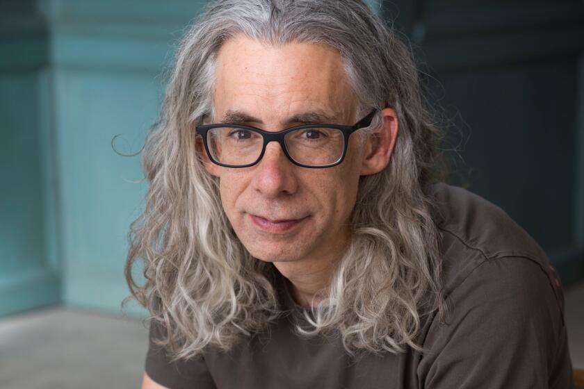 Bret Anthony Johnston, with flowing salt-and-pepper hair and a gray T-shirt, looks into the camera.