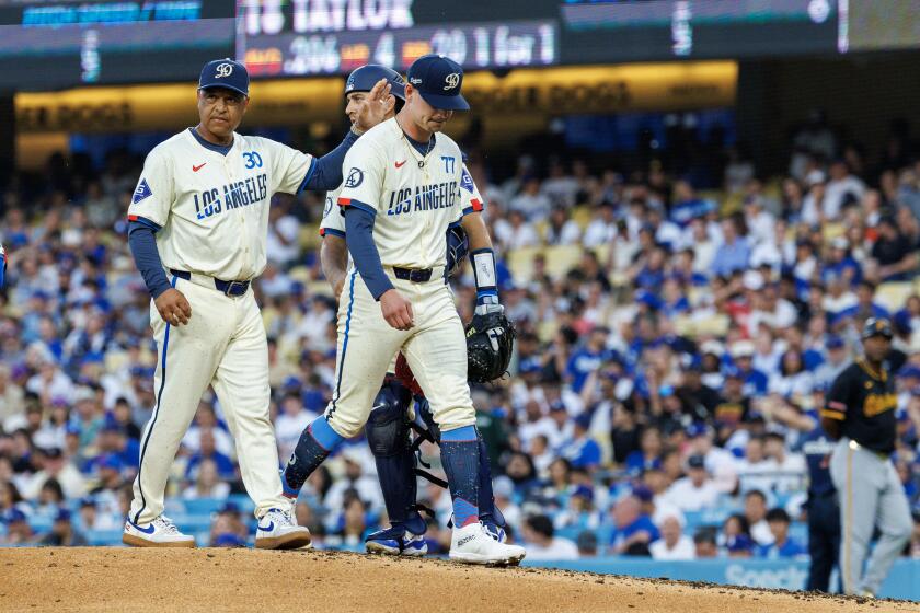 Dodgers manager Dave Roberts consoles starting pitcher River Ryan as he's pulled from the game due to a right arm injury 