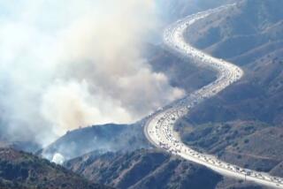 View of the smoke from the brush fire burning off the side of I-210 near Tujunga