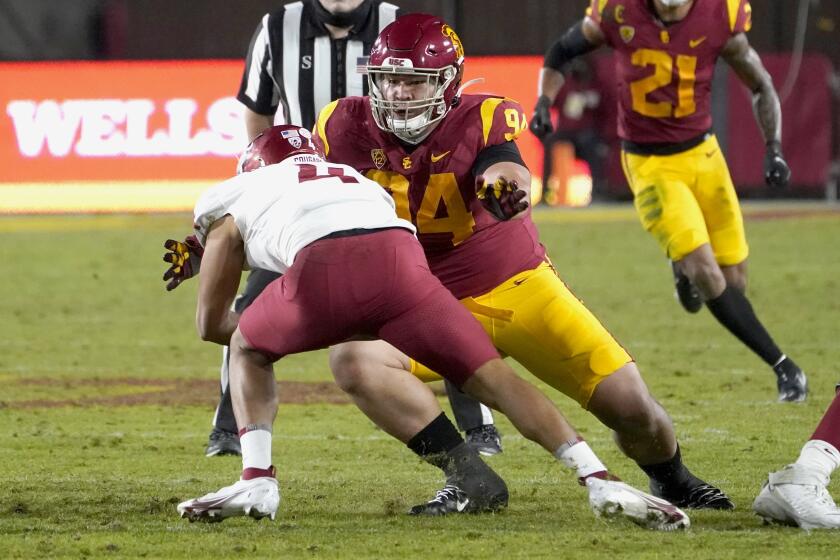 USC defensive lineman Kobe Pepe brings down Washington State quarterback Jayden de Laura 