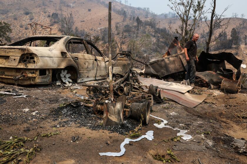 Havilah, CA, Sunday, July 28, 2024 - Sean Rains sifts through the rubble of his home that was destroyed by the Borel Fire. Rains lost two classic cars and everything inside the house was destroyed. He said he stayed to protect his home and an historic schoolhouse across the street. The schoolhouse remains. (Robert Gauthier/Los Angeles Times)