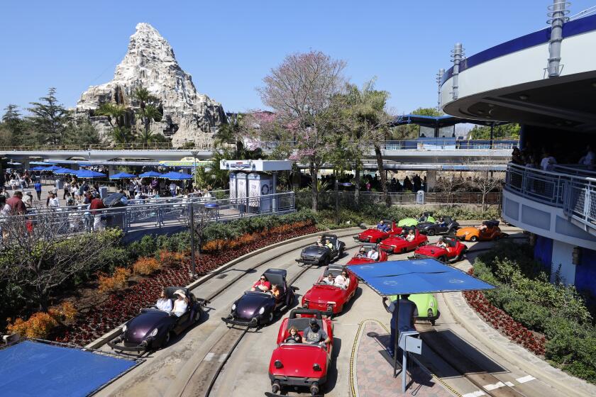 Anaheim, CA - March 11: Visitors wait in lines inside their idling cars at the end of the ride at Autopia in Tomorrowland at Disneyland. Environmental activists Zan Dubin and Paul Scott, not shown, recently filed a complaint about air pollution and noxious smells from Autopia with Southern California air quality regulators at Disneyland in Anaheim Monday, March 11, 2024. They want Disneyland to convert Autopia to electric vehicles, and to find other ways -in Tomorrowland and across the park - to bring clean energy into its storytelling. (Allen J. Schaben / Los Angeles Times)