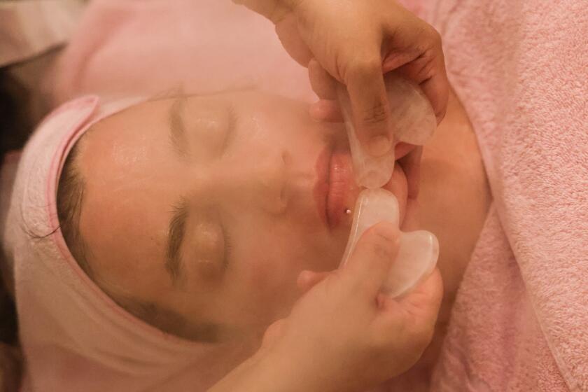 San Gabriel, CA - June 18: Yajing Lu uses an ox horn tool to massage Jackie Snow's face to release tension in the muscles, tendons and ligaments during a Bojin facial from JY Beauty on Tuesday, June 18, 2024 in San Gabriel, CA. Bojin treatments are used to alleviate pains, maintain the elasticity of the muscles and maintain the free movement of joints. (Dania Maxwell / Los Angeles Times)