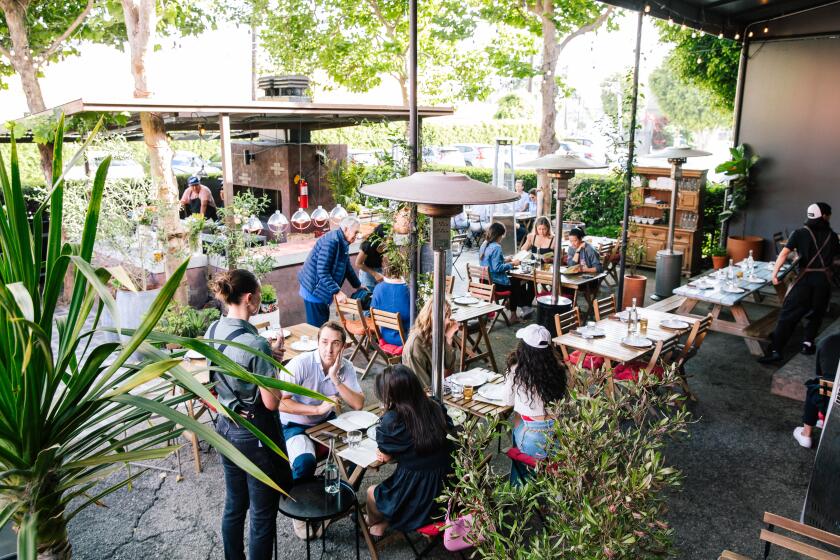 Guests enjoy a meal on the outdoor patio space at Le Great Outdoor.