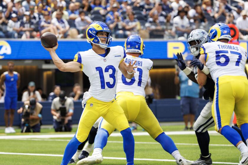 Rams quarterback Stetson Bennett (13) throws a pass against the Dallas Cowboys in their preseason game.