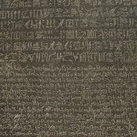 The Rosetta Stone, with Egyptian hieroglyphics in the top section, demotic characters in the middle, and Greek at the bottom; in the British Museum.