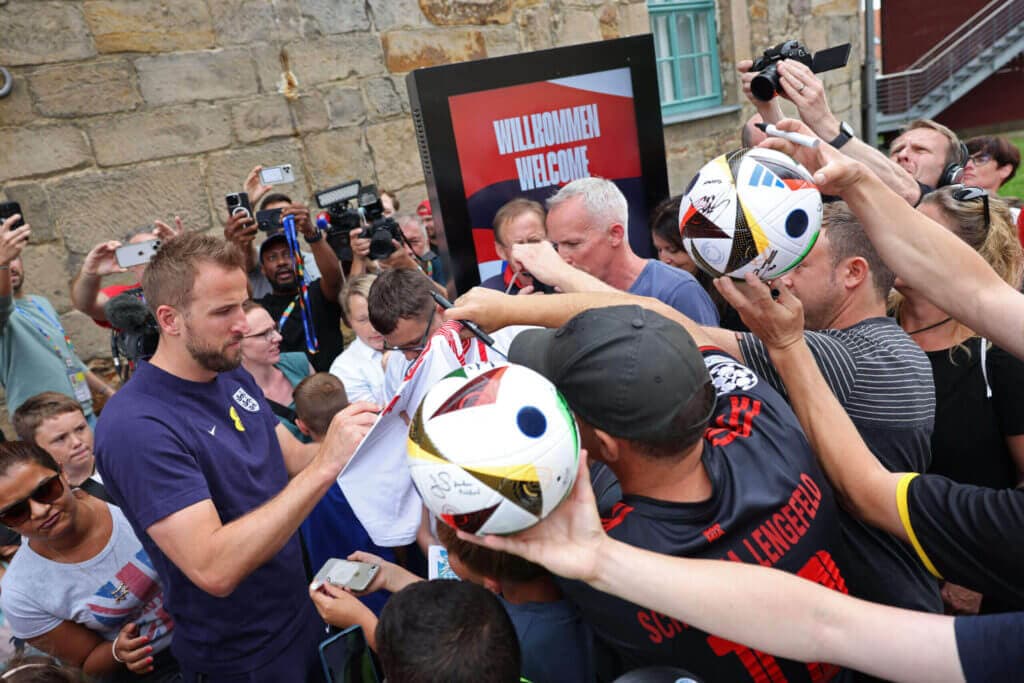 England&#039;s forward #09 Harry Kane signs autographs as he leaves the media centre at the team&#039;s base camp, the Weimarer Land golf resort, near Blankenhain, on July 12, 2024, ahead of the UEFA Euro 2024 final football match between Spain and England. (Photo by Adrian DENNIS / AFP) (Photo by ADRIAN DENNIS/AFP via Getty Images)