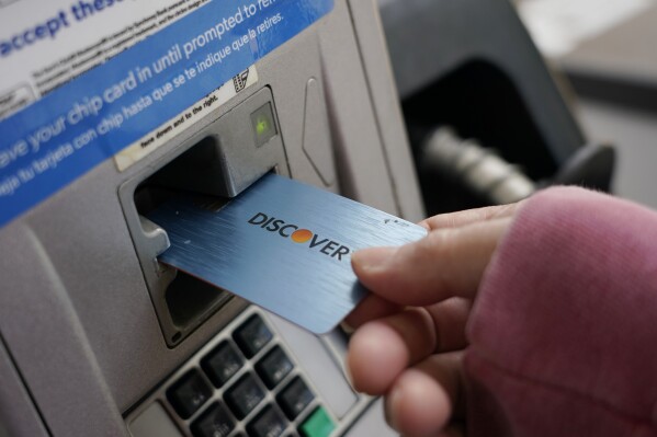 File - A Discover card is used to pay for gasoline at a Sam's Club in Madison, Miss., July 1, 2021. A combination of inflation, increased interest rates, and the end of pandemic-tied relief, such as the moratorium on student loan payments, has led to record credit card debt, experts say. (AP Photo/Rogelio V. Solis, File)