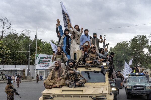 FILE - Taliban fighters celebrate one year since they seized the Afghan capital, Kabul, in front of the U.S. Embassy in Kabul, Afghanistan, Monday, Aug. 15, 2022. The Taliban on Tuesday, July 30, 2024, disavowed many Afghan diplomatic missions overseas, saying it will not honor passports, visas and other documents issued by diplomats associated with Afghanistan's former Western-backed administration. (AP Photo/Ebrahim Noroozi, File)