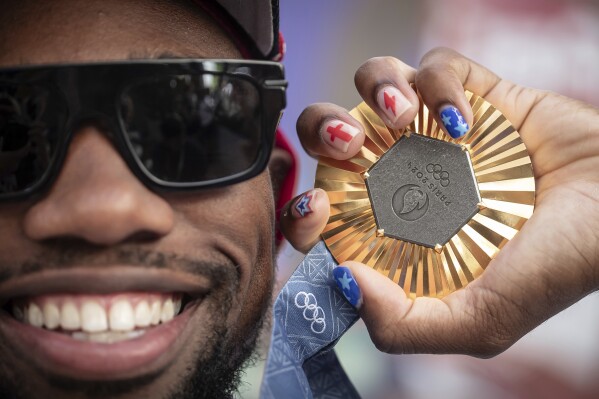 American Olympic champion Noah Lyles poses with this gold medal before an interview in Paris, France, Sunday, Aug. 11, 2024. (AP Photo/Aurelien Morissard)