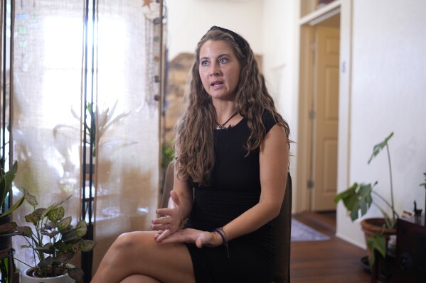 Kyleigh Thurman, one of the patients who is filing a federal complaint against an emergency room for not treating her ectopic pregnancy, talks about her experience at her studio, Wednesday, Aug. 7, 2024, in Burnet County, Texas. (AP Photo/Eric Gay)