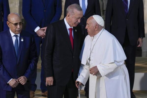 FILE - Turkey's President Recep Tayyip Erdogan, center, talks to Pope Francis during a group photo at the G7 in Borgo Egnazia, near Bari in southern Italy, June 14, 2024. Turkish President Erdogan spoke with Pope Francis on Thursday, Aug. 1, about the “immoral display” at the opening ceremony of the Paris Olympics and called for a unified stance against acts that ridicule sacred values, according to a statement from Erdogan’s office. (AP Photo/Luca Bruno, File)