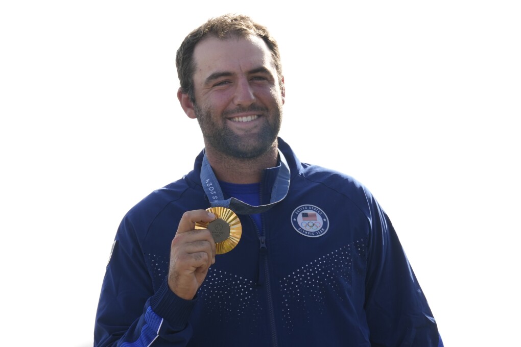 Gold medalist Scottie Scheffler, of the United States, poses with his medal following the medal ceremony for men's golf during the medal ceremony at the 2024 Summer Olympics, Sunday, Aug. 4, 2024, at Le Golf National in Saint-Quentin-en-Yvelines, France. Scottie Scheffler, of the United States, won the gold medal with Tommy Fleetwood, of Britain, silver and Hideki Matsuyama, of Japan, the bronze.(AP Photo/Matt York)