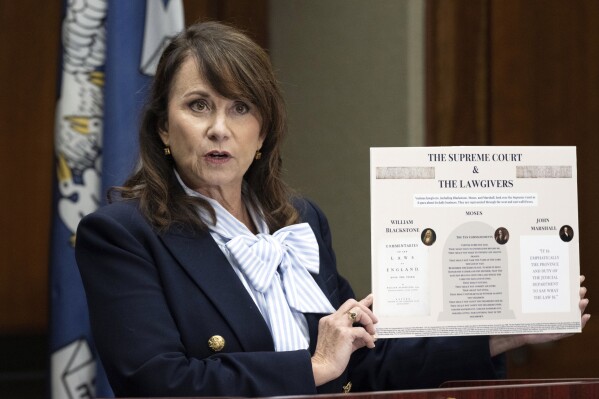 Louisiana Attorney General Liz Murrill speaks holds up a mini-display showing the Ten Commandments during a press conference regarding the Ten Commandments in schools Monday, Aug. 5, 2024, in Baton Rouge, La. Murrill announced on Monday that she is filing a brief in federal court asking a judge to dismiss a lawsuit seeking to overturn the state’s new law requiring that the Ten Commandments be displayed in every public school classroom. (Hilary Scheinuk/The Advocate via AP)