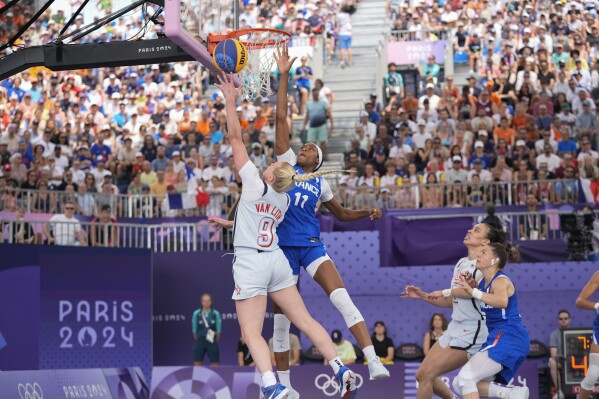 Hailey van Lith (9), of the United States, drives past Myriam Djekoundade (11), of France, in the women's 3x3 basketball pool round match during the 2024 Summer Olympics, Friday, Aug. 2, 2024, in Paris, France. The United States won 14-13. (AP Photo/Frank Franklin II)