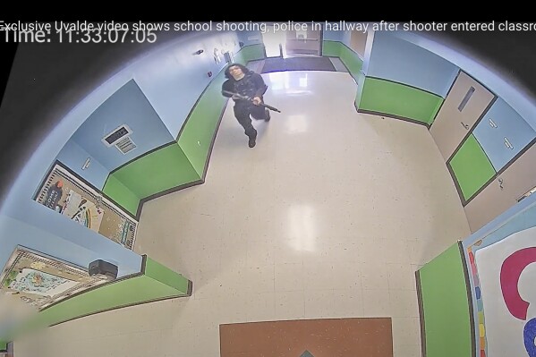 FILE - In this image from surveillance video provided by the Uvalde Consolidated Independent School District via the Austin American-Statesman, a gunman carrying an AR-15 style rifle enters and walks down a hallway at Robb Elementary School in Uvalde, Texas, Tuesday, May 24, 2022. (Uvalde Consolidated Independent School District/Austin American-Statesman via AP, File)