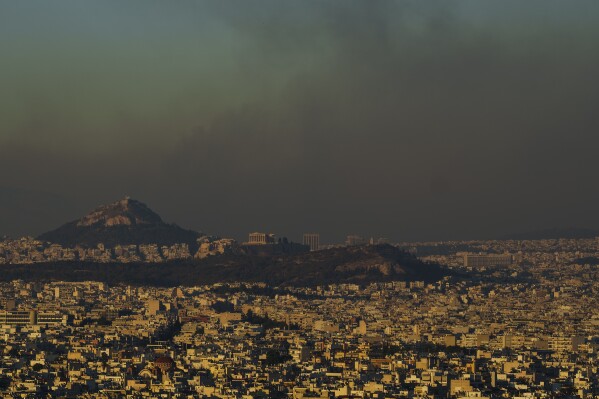 A general view of Athens with the Acropolis hill is seen as fire burns the northern part of the city on Monday, Aug. 12, 2024, Hundreds of firefighters are tackling a major wildfire raging out of control on the fringes of the Greek capital. (AP Photo/Petros Giannakouris)