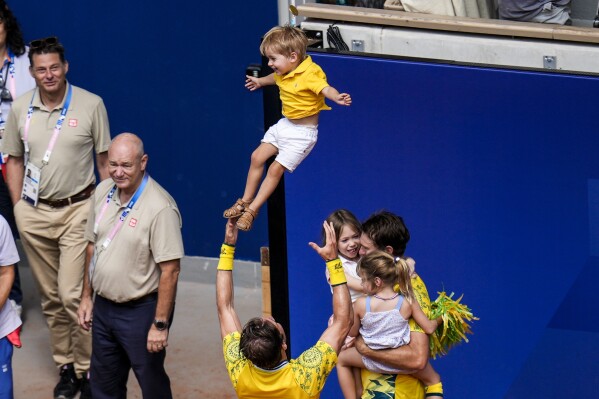 Matthew Ebden and John Peers of Australia celebrate with their children after they defeat Austin Krajicek and Rajeev Ram of the United States in their men's doubles gold medal match at the Roland Garros stadium, at the 2024 Summer Olympics, Saturday, Aug. 3, 2024, in Paris, France. (AP Photo/Manu Fernandez)