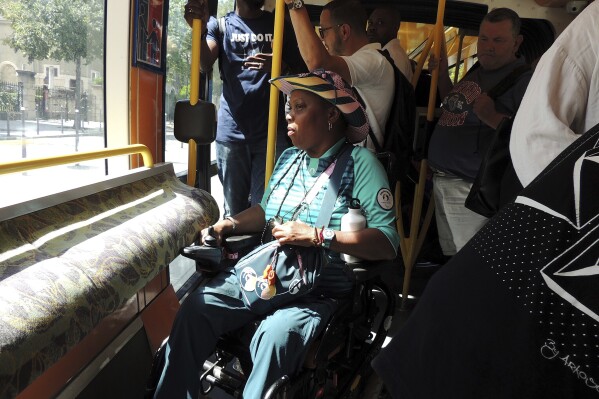 Ndieme Lame, a 57-year-old volunteer for the Paris 2024 Olympic and Paralympic Games, rides on the Tramway T3a line, during the 2024 Summer Olympics, Wednesday, Aug. 7 2024, in Paris, France. (AP Photo/Tom Nouvian)