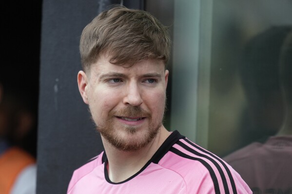 FILE - Jimmy Donaldson, the popular YouTube video maker who goes by MrBeast, wears a Lionel Messi jersey as he stands in a sideline box at the start of an MLS soccer match between Inter Miami and CF Montreal, March 10, 2024, in Fort Lauderdale, Fla. (AP Photo/Rebecca Blackwell, File)